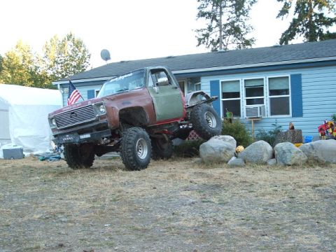 1976 GMC Sierra 2500 - Modified 1976 GMC Sierra 2500 pickup truck with large off-road tires and a two-tone paint scheme.