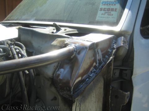 1990 Ford Bronco - Fabricated welded metal fender bracketry on a truck with a 2006 SCORE pit pass sticker on the windshield.