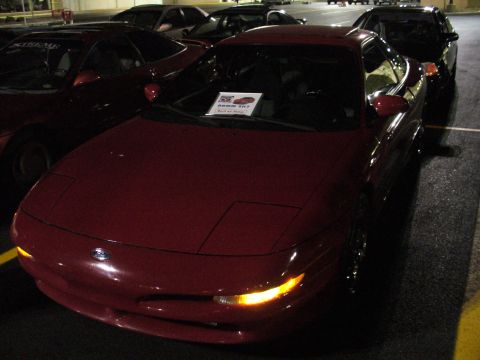 1991 Ford Probe - A red 1991 Ford Probe is parked in a lot at night, with other vehicles visible around it.