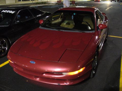 1991 Ford Probe - A red 1991 Ford Probe with flame decals is parked next to another car that also appears to be a Probe.
