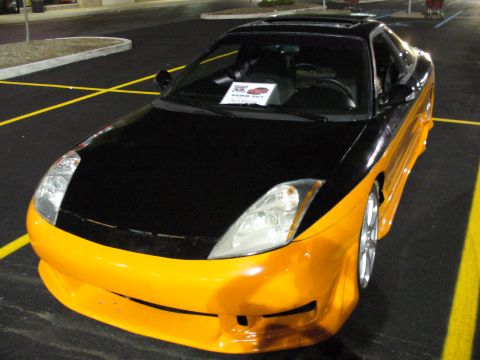 1991 Ford Probe - This customized coupe features a striking two-tone paint scheme with a black hood and roof contrasting with an orange front end and side pa…
