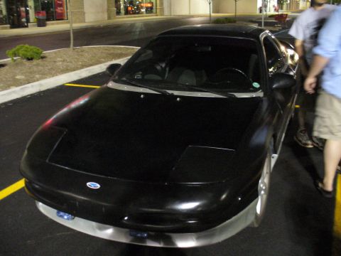 1991 Ford Probe - A black 1991 Ford Probe is parked in a lot at night, with its headlights down.