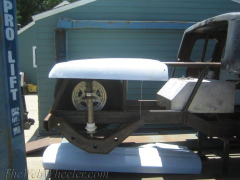 1990 Ford Bronco - white fiberglass body panel and steering components sit on a bare frame next to a blue 'Pro Lift' two-post hoist.