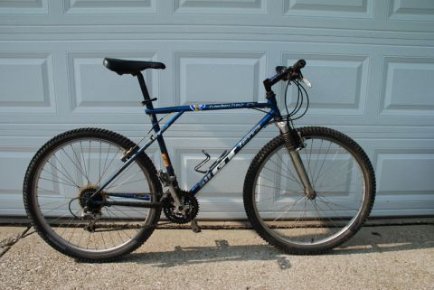 1997 Ford Probe - A blue GT mountain bike with a water bottle cage is shown parked in front of a garage door.