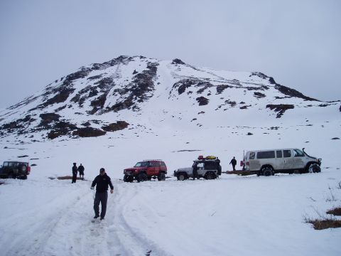 2000 Ford E350 - A white Ford E350 van is seen in a snowy landscape alongside other off-road vehicles.