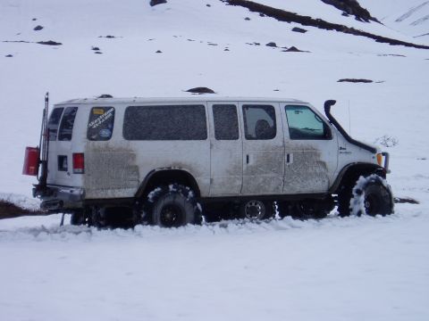2000 Ford E350 - Modified Ford E350 van with off-road tires and snorkel navigating snowy terrain.