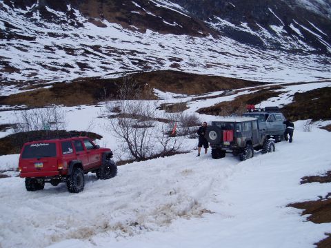 2000 Ford E350 - Several off-road vehicles navigate a snowy mountain pass.