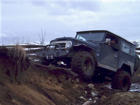 2000 Ford E350 - Toyota Land Cruiser FJ40 navigates a challenging muddy terrain.