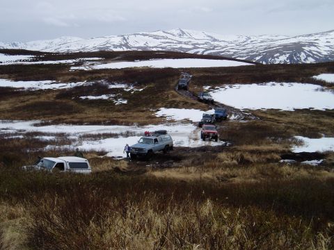 2000 Ford E350 - A convoy of SUVs and trucks navigates a challenging off-road course in a winter landscape.