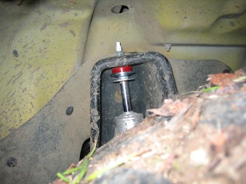 2001 Jeep Wrangler - Close-up of a vehicle's suspension component, showing a shock absorber mount with visible dirt and debris.