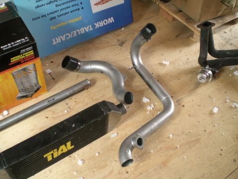 1995 Ford Probe - Aftermarket intercooler and piping kit components laid out on a workbench.