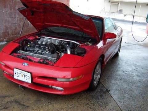 1995 Ford Probe - Front view of a red 1995 Ford Probe, hood raised to reveal the engine bay.