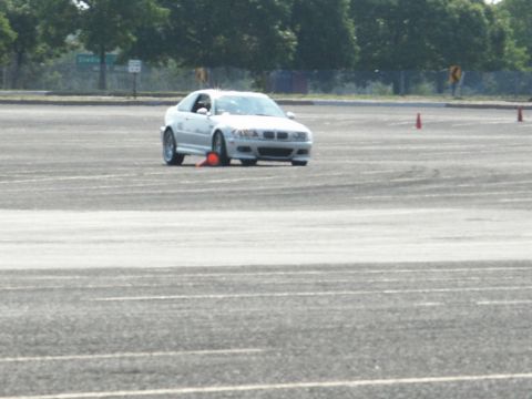 2001 Mercury Grand Marquis - BMW M3 coupe on a track, navigating cones. Grille suggests early 2000s model.