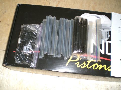 1995 Ford Probe - A box containing various engine components, including clips and rods, is laid out on a surface.