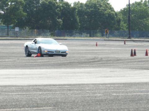 2001 Mercury Grand Marquis - A silver Chevrolet Corvette C5 navigates an autocross course marked by orange cones.