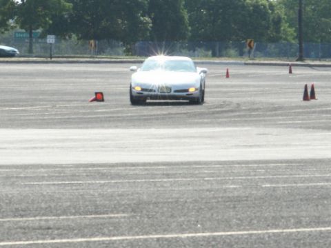 2001 Mercury Grand Marquis - A silver sports car navigates an asphalt course marked with orange cones.