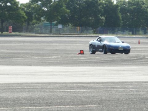 2001 Mercury Grand Marquis - A blue sports car is seen on a paved track, maneuvering around orange cones during a timed event.