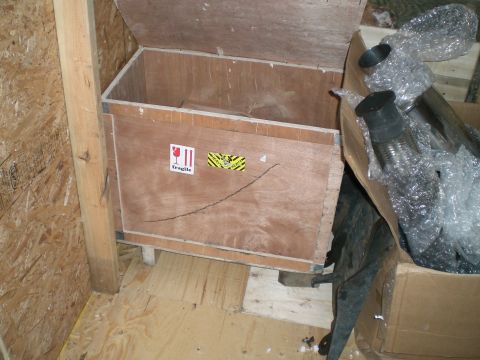 1995 Ford Probe - Wooden crate with fragile shipping labels, holding exhaust components wrapped in protective bubble wrap.
