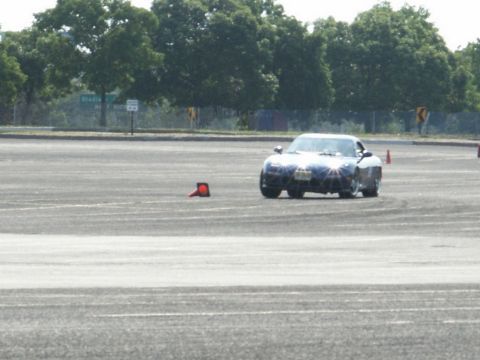 2001 Mercury Grand Marquis - A dark blue sports car navigates a course marked by orange cones on a paved surface.