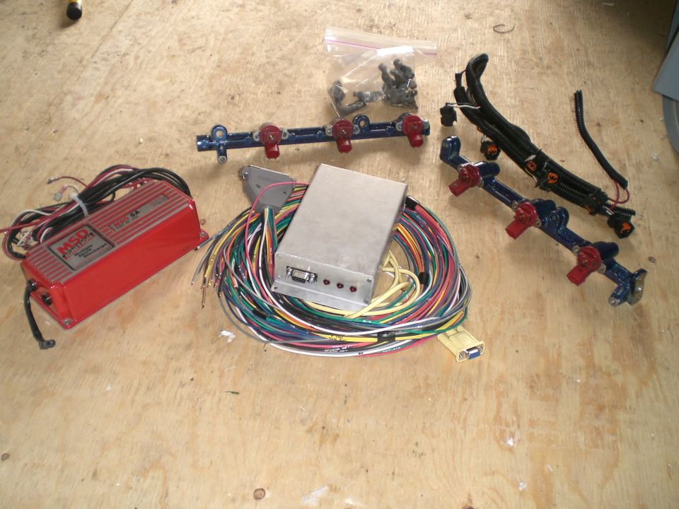 Red MSD ignition box, silver ECU, fuel rail with injectors, and wiring harness