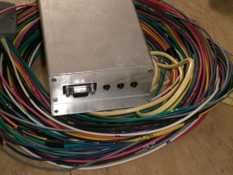 1995 Ford Probe - Bare aluminum standalone engine-management ECU box with a 9-pin D-sub serial port and three red status LEDs on its end plate, sitting on a…