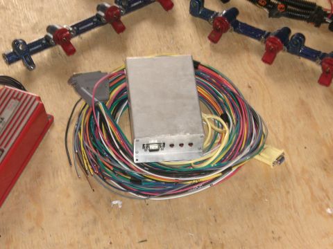 1995 Ford Probe - A set of fuel injectors and a complex wiring harness are laid out on a wooden surface.