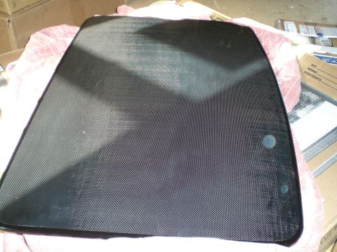 1995 Ford Probe - A carbon fiber panel with a fine plain-weave surface and glossy clear coat, roughly trapezoidal with rounded corners and two small round mo…
