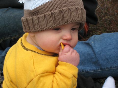 2000 Ford E350 - Baby eating a snack while wearing a knit hat and yellow shirt.