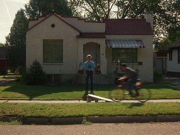 1986 Ford Bronco - A house in a suburban neighborhood with two people, one on a bicycle.