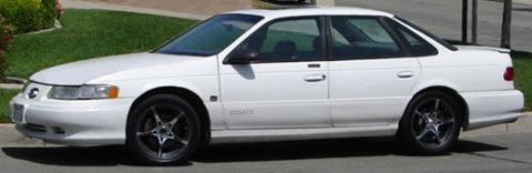 1993 Ford Taurus - A white 1993 Ford Taurus sedan is shown from a three-quarter front angle on a residential street.