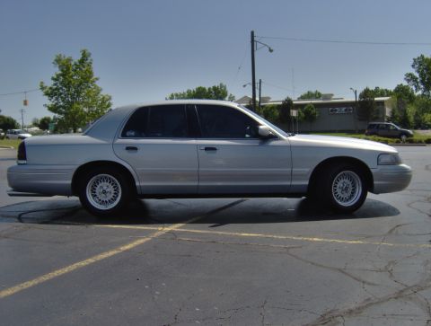 2002 Ford Crown Victoria - Side profile of a silver 2002 Ford Crown Victoria parked in a lot.