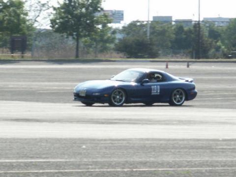 2001 Mercury Grand Marquis - A blue Mazda RX-7 with racing number 113 D navigates a track during an event.