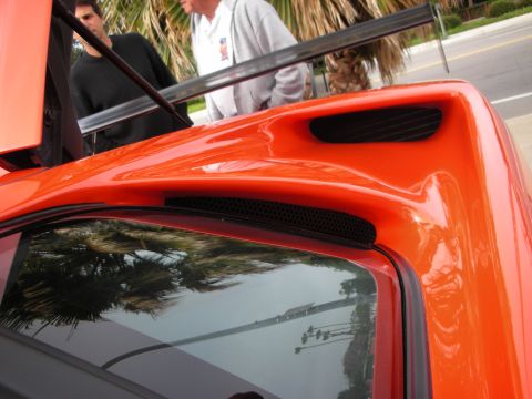 1998 Ford Crown Victoria - Close-up of an orange sports car's rear section, showing a spoiler and ventilation details.
