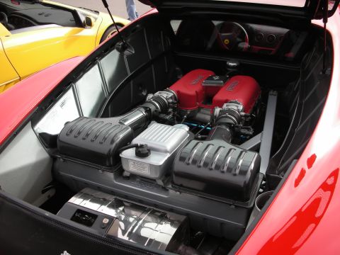 1998 Ford Crown Victoria - The engine bay of a red Ferrari is open, revealing its powerful V8 engine and intake system.