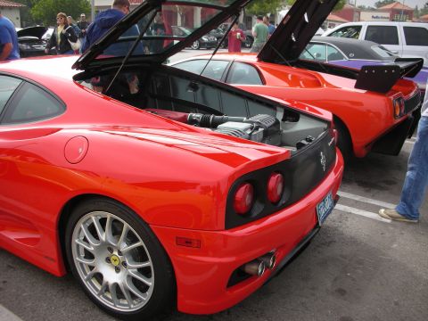1998 Ford Crown Victoria - Two red Ferraris parked side-by-side, one with its engine cover open.