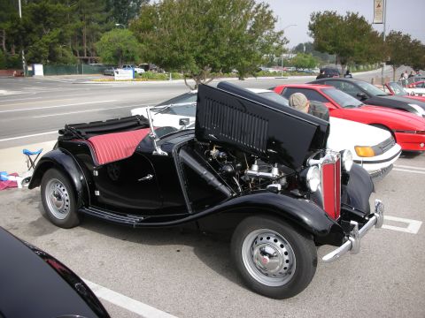1998 Ford Crown Victoria - Black convertible with red interior and exposed engine at a car meet.