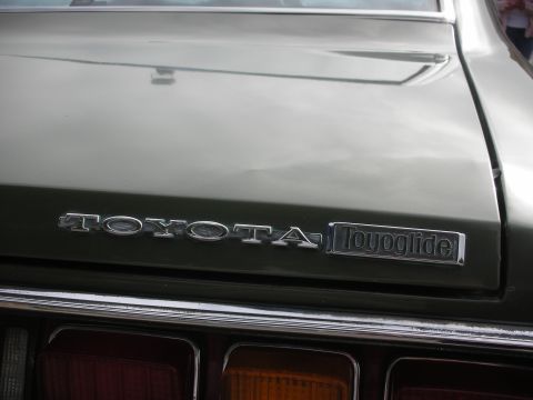 1998 Ford Crown Victoria - The rear of a green vehicle displays the TOYOTA badge and a Toyoglide emblem.