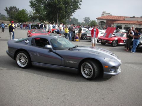 1998 Ford Crown Victoria - A gray Dodge Viper GTS is parked at an outdoor car meet with other vehicles and people around.