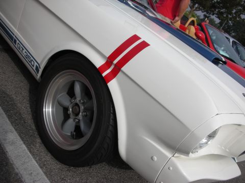 1998 Ford Crown Victoria - Close-up of a white 1965 Ford Mustang GT350 showing its distinctive racing stripes.