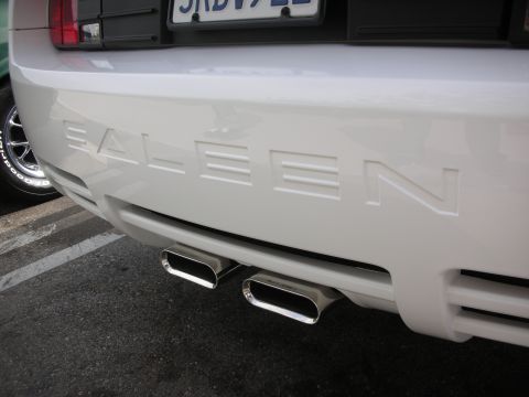1998 Ford Crown Victoria - The rear of a white vehicle shows 'SALEEN' badging and dual exhaust pipes.