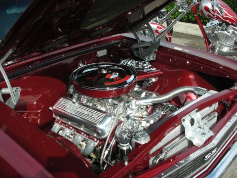 1998 Ford Crown Victoria - A highly customized engine bay is shown, with a prominent chrome air cleaner and valve covers. Another vehicle, a motorcycle, is partially…