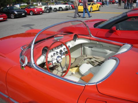 1998 Ford Crown Victoria - The interior of a classic red Chevrolet Corvette is shown, with other vehicles parked in the background.
