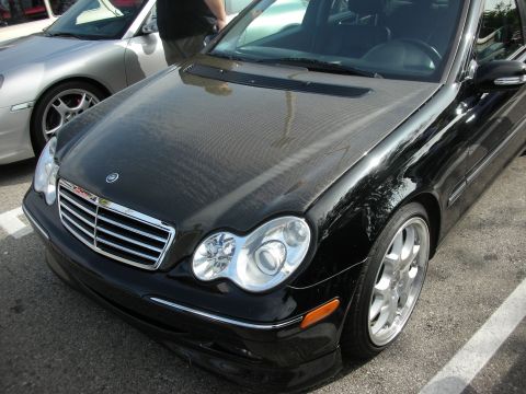 1998 Ford Crown Victoria - A black Mercedes-Benz C-Class is parked next to a silver Porsche.