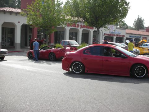 1998 Ford Crown Victoria - A red Dodge Neon SRT-4 is parked on the street with other vehicles nearby.
