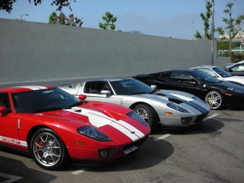 1998 Ford Crown Victoria - Several high-performance sports cars, including Ford GTs and a Ferrari, are lined up in a parking area.
