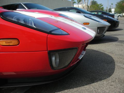 1998 Ford Crown Victoria - Three Ford GT sports cars are lined up, with the front of a red one in focus.