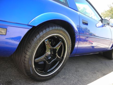 1998 Ford Crown Victoria - Detail shot of a blue sports car's wheel and side panel.
