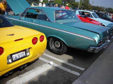 1998 Ford Crown Victoria - A yellow Corvette and a turquoise classic car are parked side-by-side at an outdoor event.