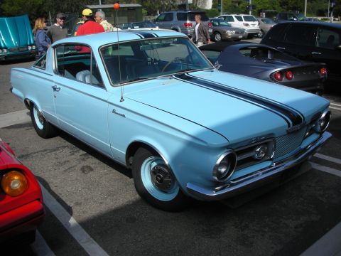 1998 Ford Crown Victoria - Light blue 1964 Plymouth Barracuda with black racing stripes, parked at a car meet.