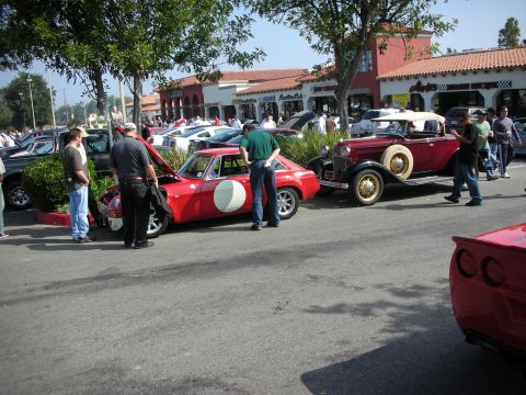 1998 Ford Crown Victoria - Cars gathered at an outdoor event, a red sports car and a vintage convertible.